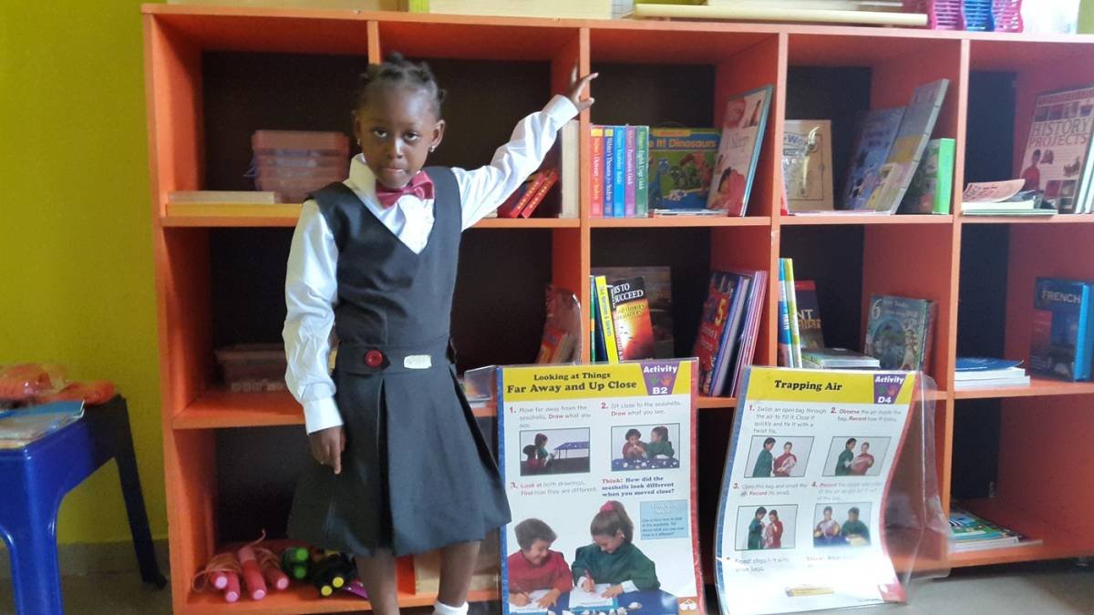 Young Lilydion scholar exploring books in the school library